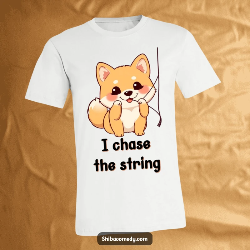 Funny Shiba Inu t-shirt depicting a dog with bright, curious eyes joyfully batting at a dangling string, showcasing pure fun.